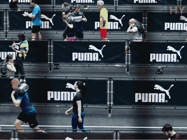 HYROX athletes doing HYROX Sandbag Lunges mid race.