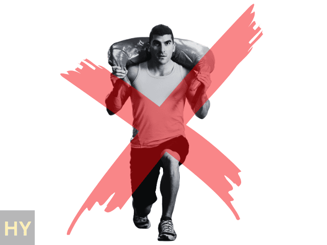 Man performing a HYROX Sandbag Luge with a red cross over the top of the image